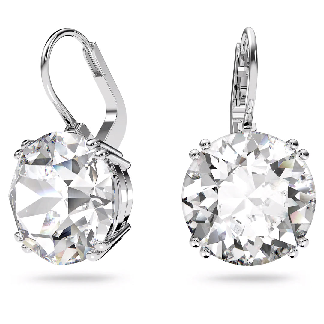 Close-up of two sophisticated drop earrings from the Swarovski Millenia collection, each adorned with a large, round-cut clear gemstone. The rhodium-plated Swarovski earrings feature a lever-back closure, highlighting their glistening and detailed design against a white background.