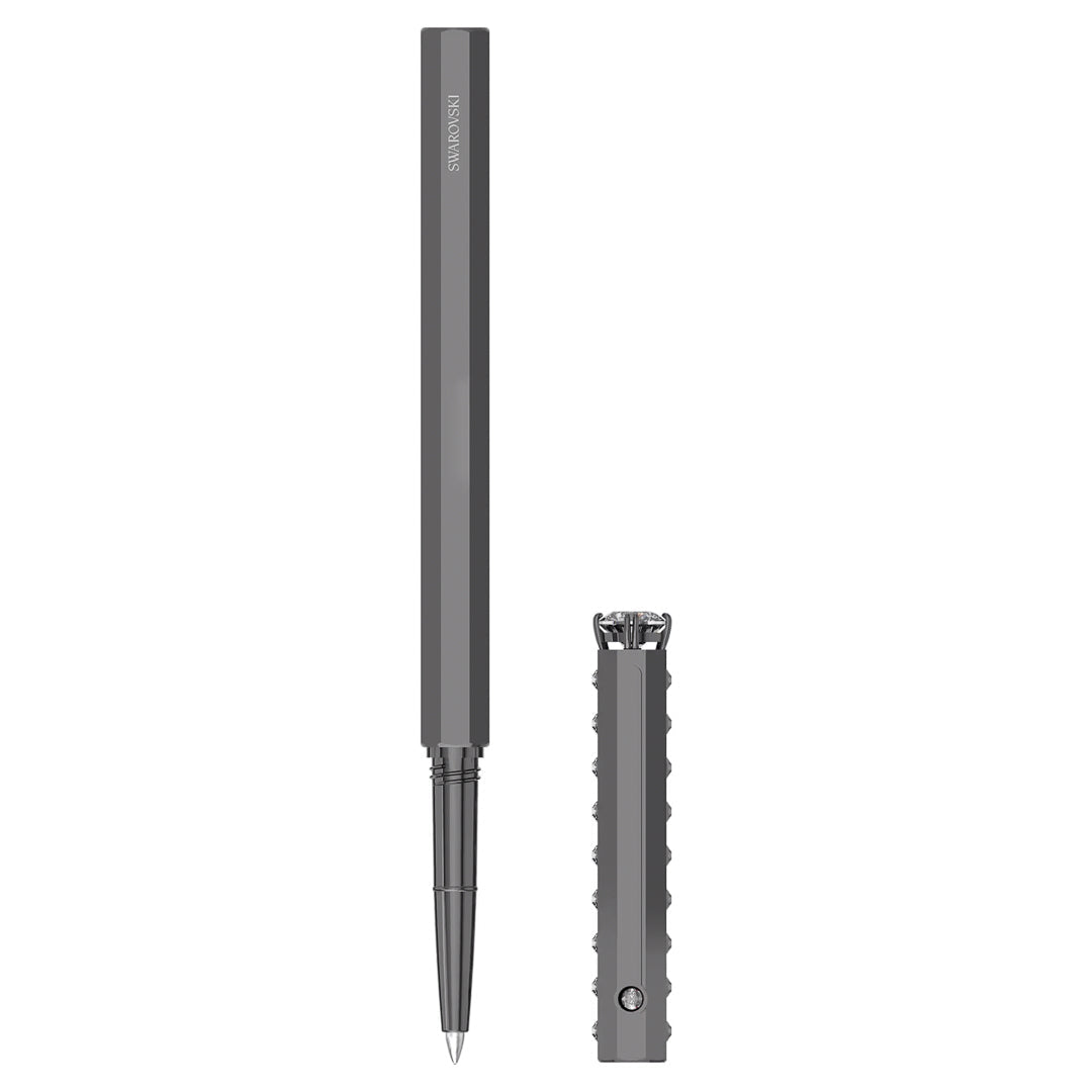 A stylish, metallic gray Swarovski Ballpoint Pen is showcased with its cap removed and placed alongside it. This pen boasts a contemporary design with an angular, hexagonal barrel and ridged features on the cap for enhanced grip, effortlessly combining elegance and practicality.