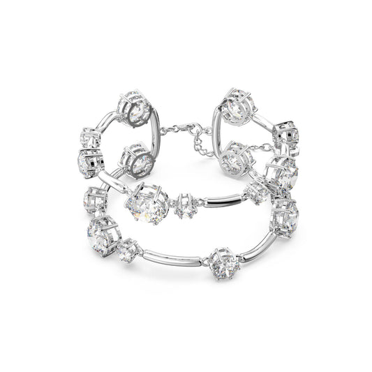 Introducing the Swarovski Round Cut Crystal Constella Double Bangle, a sophisticated piece from the renowned Swarovski brand. This silver bracelet features multiple round, intricate crystal accents linked by elegantly curved rhodium-plated connectors to capture light and exude a dazzling sparkle. The bangle-style design is double-layered and equipped with a secure clasp and extender chain for added versatility.
