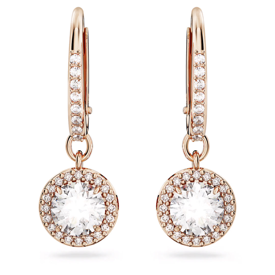 Introducing the Swarovski Una Angelic Drop Earrings from Swarovski: Exquisite rose gold-tone dangle earrings showcasing a stunning large round crystal at their center, encircled by smaller crystals. The hoops are embellished with a row of glittering crystals, adding an extra touch of sparkle to these elegant earrings.