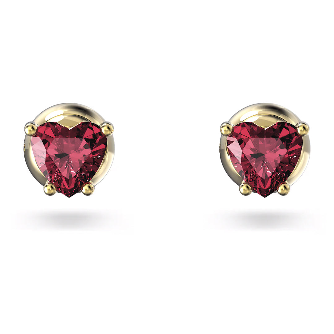The Swarovski Chroma Stud Earrings feature heart-shaped stones set in gold fixtures. Positioned against a white background, these earrings highlight their vibrant color and elegant design, embodying the sophistication of the Swarovski brand.