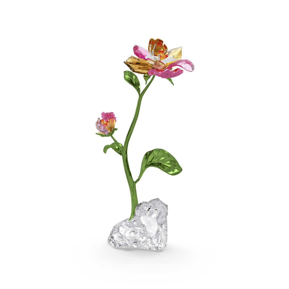 The Swarovski Idyllia Flower Large, a stunning glass sculpture from Swarovski, showcases pink and yellow petals, green leaves, and a small bud. This elegant piece stands on a clear textured base against a plain white background and is available through Raffi Jewellers, proudly celebrated by Swarovski Canada.