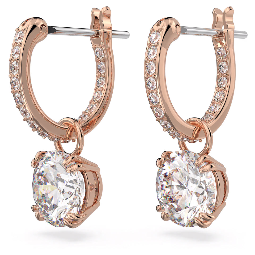 The Swarovski Stilla Drop Earrings by Swarovski boast a luxurious and polished look, with gold drop earrings embellished with small diamonds and crystals, highlighted by large round diamond pendants at the bottom. The subtle rose gold-tone plating enhances their elegance.