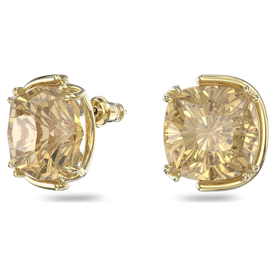 Close-up image of two cushion-cut yellow gemstones set in gold-tone plated prong earring mounts. The stones have facets that catch the light, creating a radiant effect. These stunning Swarovski Harmonia Stud Earrings are displayed against a plain white background.