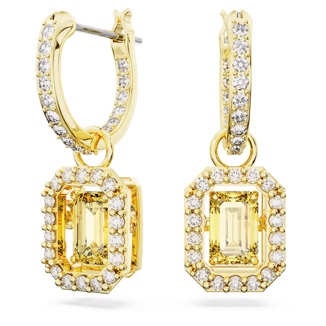 The Swarovski Una Drop Earrings from Swarovski feature gold hoops adorned with dazzling rectangular yellow gemstones, encircled by pavé crystals. Their intricate design embodies a luxurious and elegant style.