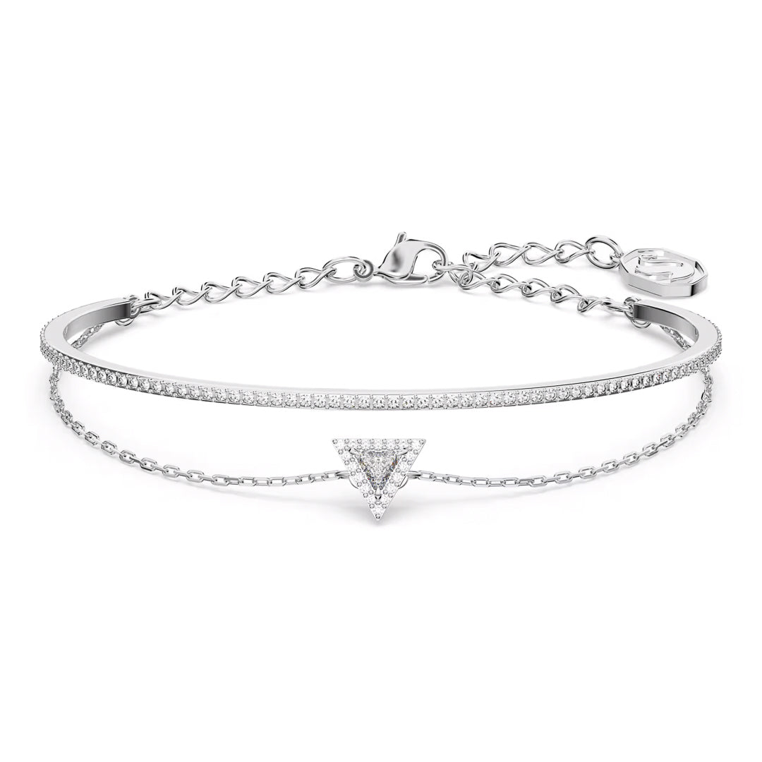 The Swarovski Stilla Bracelet is a delicate silver accessory featuring a rhodium-plated band with two layers: one plain and one chain adorned with a small triangular charm set with tiny crystals. Reminiscent of Swarovski's iconic designs, this bracelet includes an adjustable clasp.