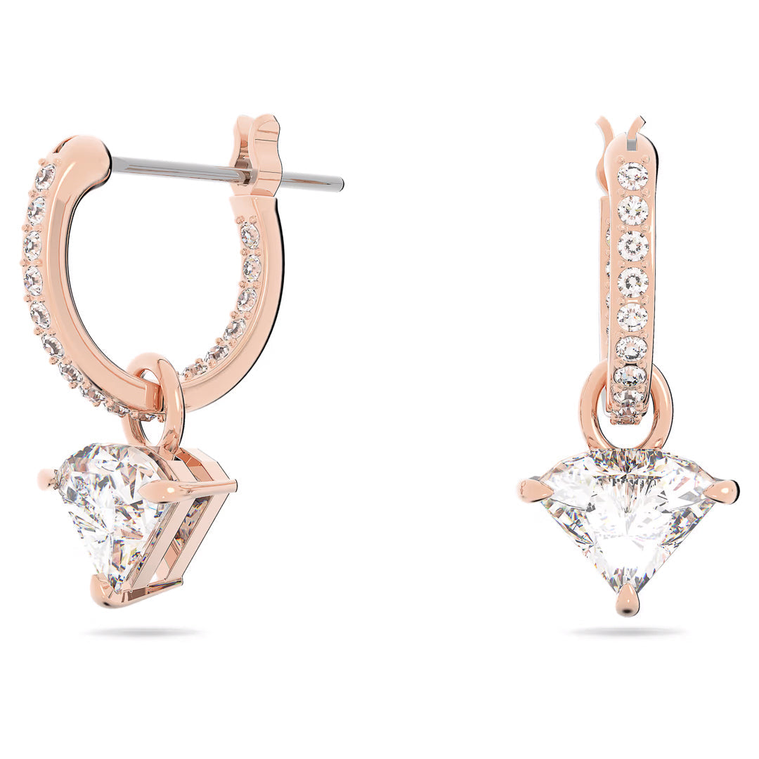 A pair of Swarovski Stilla Drop Earrings, crafted by Swarovski, features a rose gold-tone hoop adorned with sparkling diamond embellishments. Each earring boasts a large, triangle-cut crystal hanging gracefully from the hoop, infusing elegance and brilliance into the design reminiscent of glamorous Swarovski pieces.