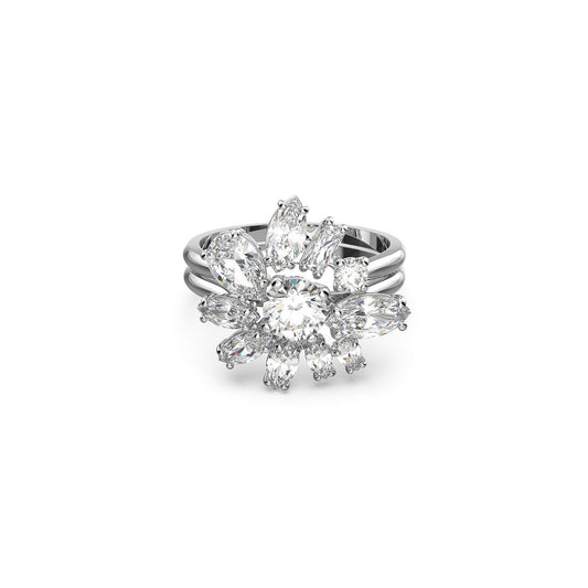 Introducing the Swarovski Mixed Cuts Gema Cocktail Ring: a rhodium-plated silver band featuring a central round diamond, elegantly surrounded by petal-shaped marquise diamonds in a floral design. The band splits into three strands, enhancing the ring's intricate beauty, making it perfect for any occasion.