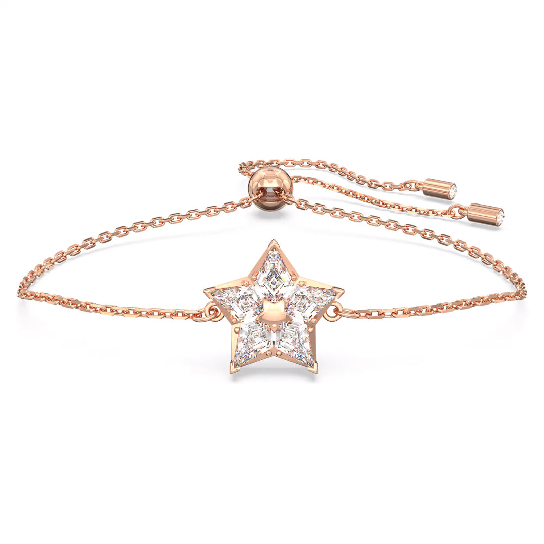 The Swarovski Stella Bracelet by Swarovski is a delicate rose gold-tone plated piece featuring a central star-shaped pendant encrusted with sparkling crystals. It includes an adjustable chain with a sliding clasp for ideal size customization.