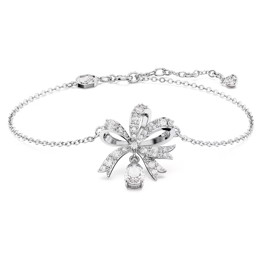 Introducing the Swarovski Hyperbola Bracelet, an exquisite piece by Swarovski. This delicate silver bracelet is adorned with a central floral design, encrusted with small diamonds and complemented by a pear-shaped diamond drop. Rhodium plated for extra luster, it features an adjustable chain and clasp to ensure secure fastening.
