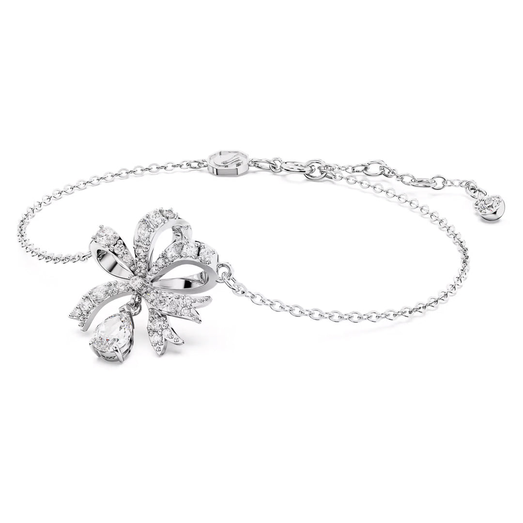 Introducing the Swarovski Hyperbola Bracelet: a delicate silver piece with an elegant bow-shaped design, adorned with sparkling crystals using the chattonage technique. Its rhodium-plated finish adds a refined touch, while the adjustable chain ensures it fits perfectly on various wrist sizes. Crafted by Swarovski, this bracelet is the epitome of elegance and sophistication.