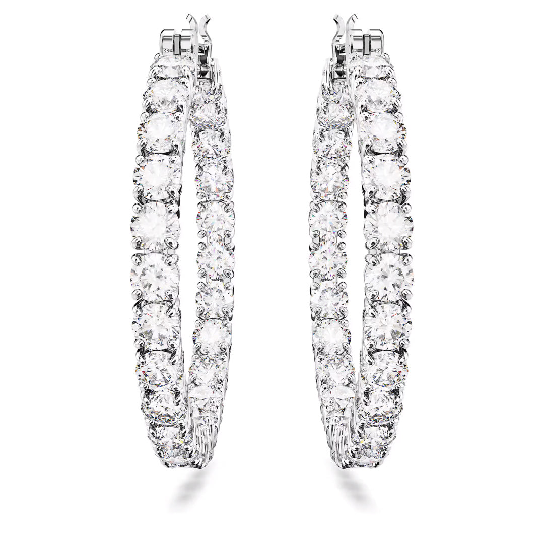 A pair of exquisite Swarovski Matrix hoop earrings, adorned with a row of round-cut zirconia and carefully set in rhodium-plated white metal, is elegantly showcased against a pristine white backdrop. The large hoops are perfectly symmetrical.