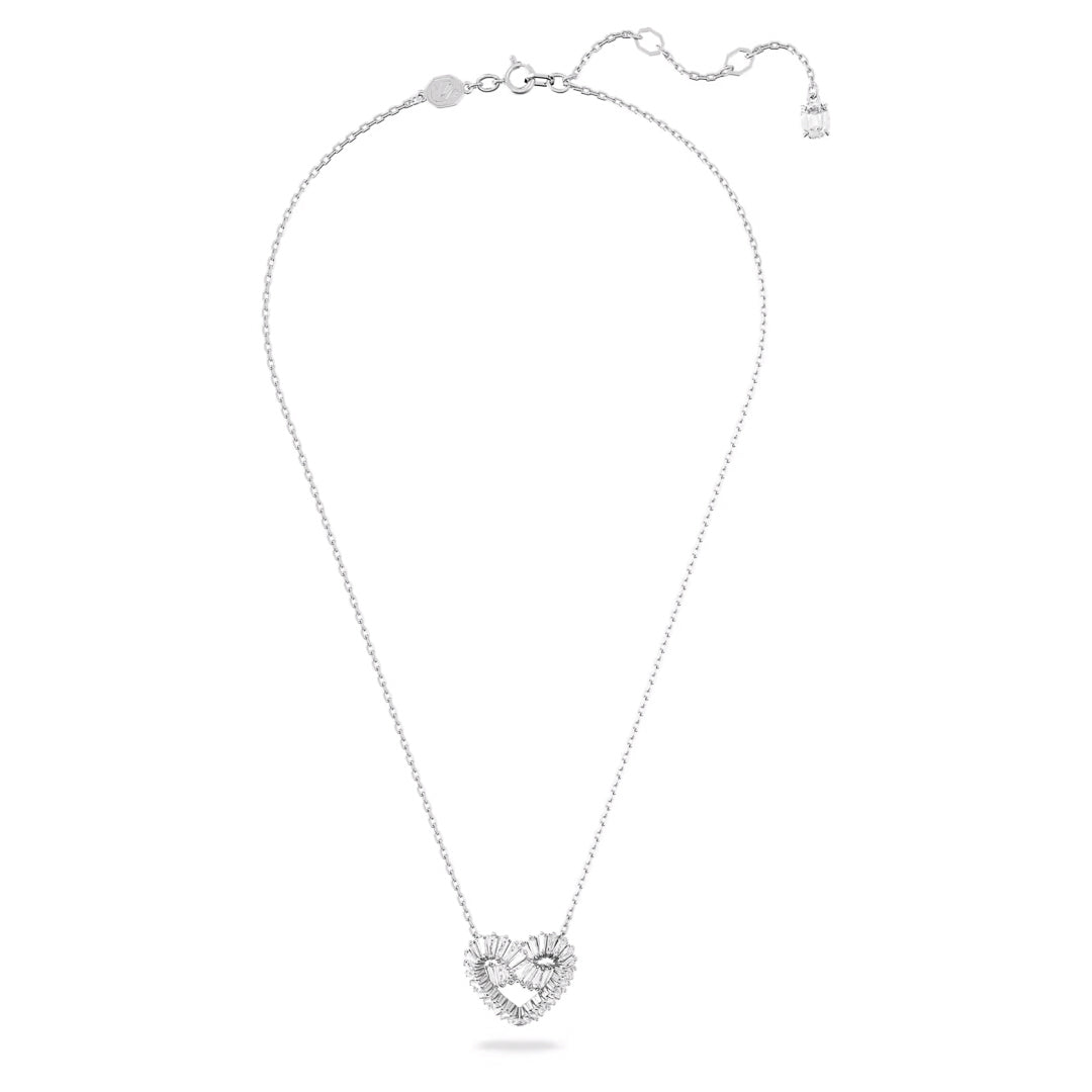 The Swarovski Matrix Necklace Pendant by Swarovski is a silver necklace featuring a delicate rhodium-plated chain and a heart-shaped pendant with intricate designs reminiscent of petals or leaves. The adjustable clasp includes a small dangling charm, enhancing the elegance of the overall design.