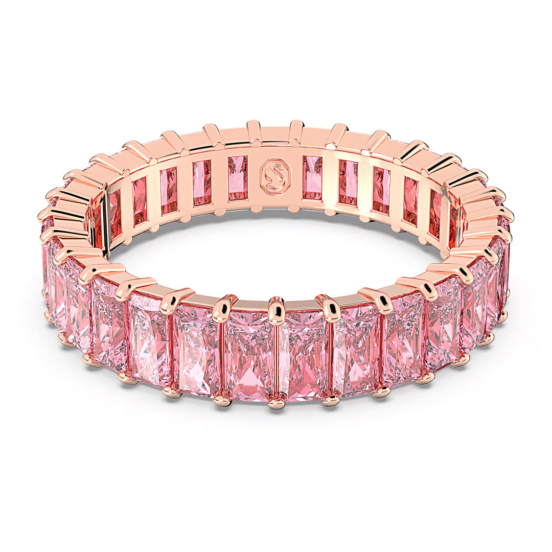 The Swarovski Matrix Baguette Ring, crafted by Swarovski, showcases a rose gold-tone plated band embellished with rectangular pink stones, offering a sparkling and elegant aesthetic.