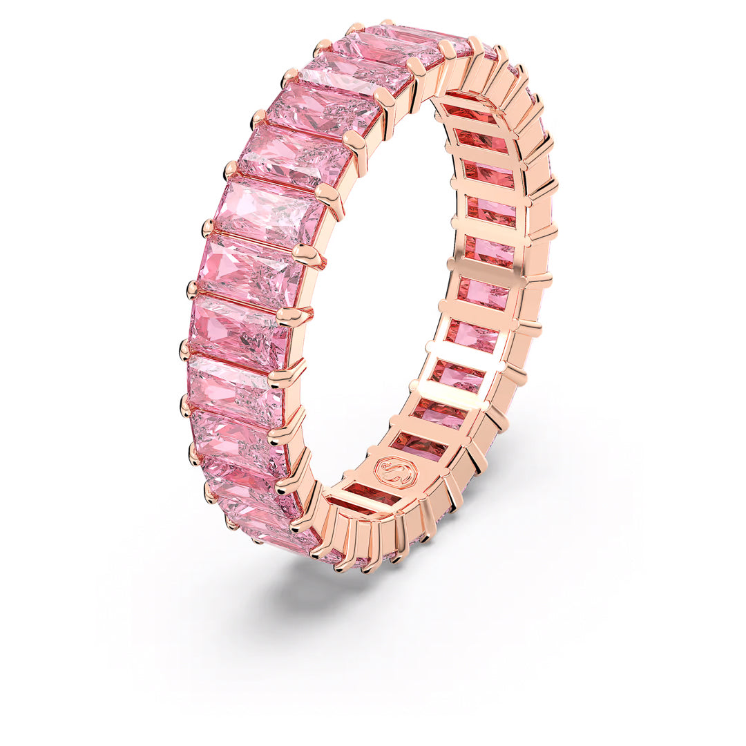 Introducing the Swarovski Matrix Baguette Ring, a stunning rose gold-tone plated creation from the renowned brand Swarovski. It features a continuous row of rectangular pink stones arranged in an elegant, modern design. Displayed beautifully on a plain white background, this exquisite piece is perfect for adding sophistication to any collection.