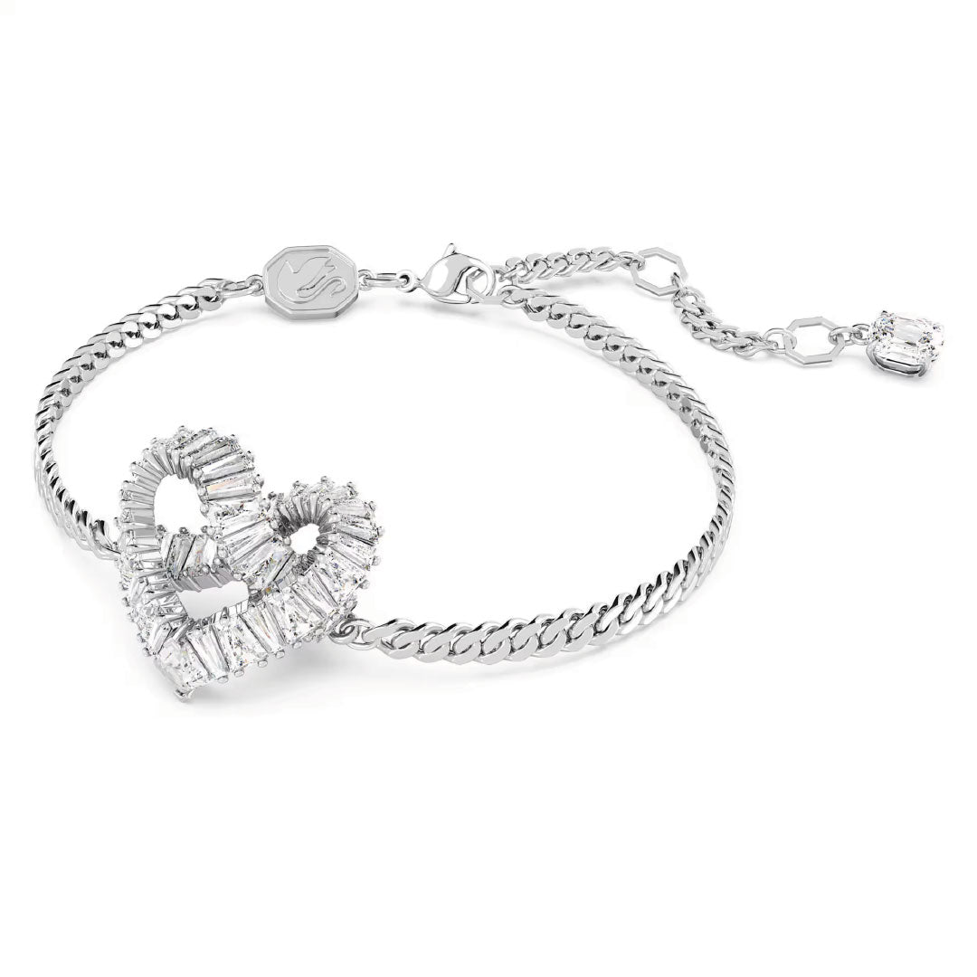 The Swarovski Matrix Bracelet is a rhodium-plated accessory featuring a heart-shaped charm embellished with sparkling crystals. The chain includes a lobster clasp and offers an adjustable length, ending with an extra crystal-encrusted charm. This exquisite piece from Swarovski is the perfect jewelry gift for any occasion.
