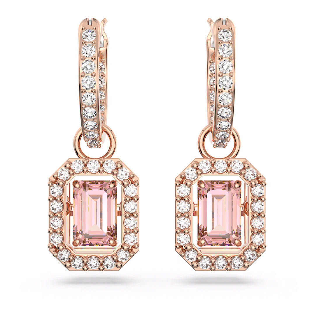 The Swarovski Una Drop Earrings in a rose gold-tone feature pink emerald-cut center stones, beautifully encircled by small clear crystals, and dangle from hoops embedded with crystals. These stunning pieces exemplify the timeless craftsmanship of Swarovski.