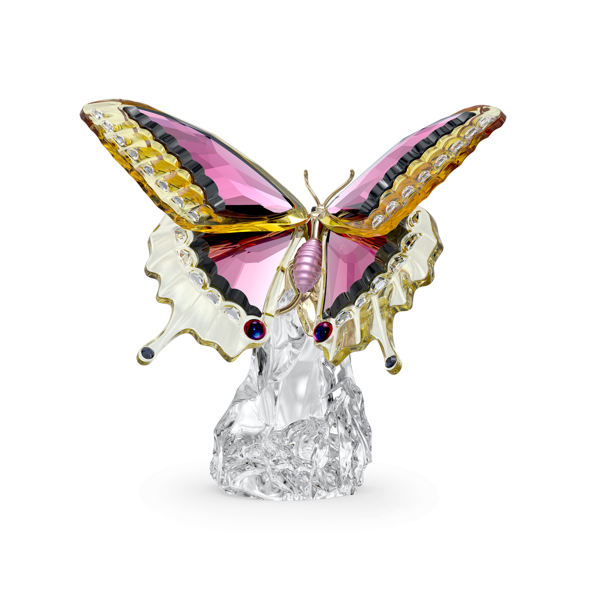 The Swarovski Idyllia Butterfly by Swarovski features a glass figurine with pink, yellow, and clear wings perched on a textured clear glass base against a white background, showcasing a nature-inspired design that makes it an elegant crystal decoration.