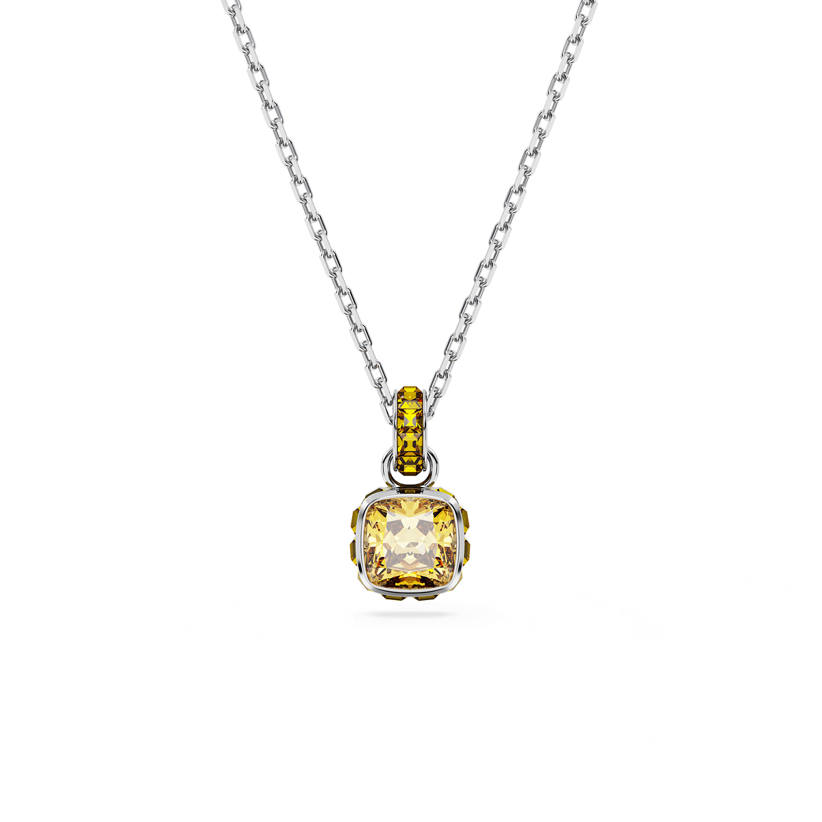 Introducing the Swarovski Birthstone Pendant: a rhodium-plated silver chain necklace showcasing a square-cut yellow gemstone pendant, inspired by November’s birthstone. The pendant features a loop adorned with small matching yellow stones, echoing the vibrant main gem. Expertly crafted in true Swarovski style (Style Number: [insert style number]), this elegant piece is presented against a plain white background and embodies the timeless sophistication found at Raffi Jewellers.