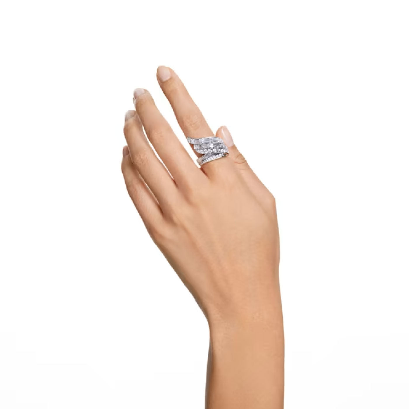 A hand with a light skin tone is raised against a plain white background, beautifully displaying the Swarovski Hyperbola Cocktail Ring. Crafted by Swarovski from recycled metal and adorned with sparkling Swarovski Zirconia, this statement piece elegantly graces the fingers.