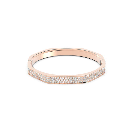 The Swarovski Dextera Bangle from Swarovski is a chic accessory featuring a modern octagonal shape and a sophisticated rose gold-tone finish. It is adorned with rows of small pavé crystals, offering a design that effortlessly combines simplicity and elegance for a contemporary, luxurious look.