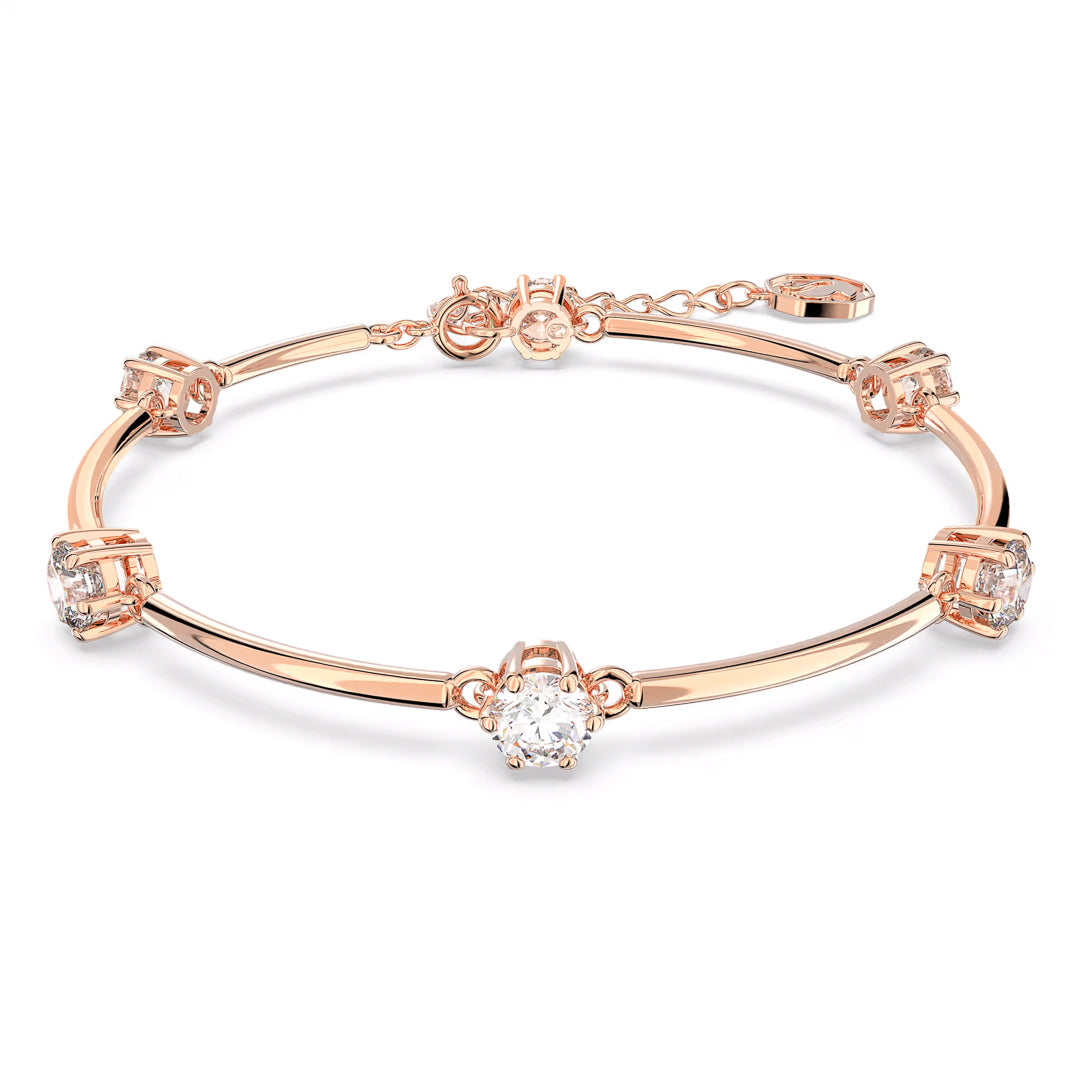 The Swarovski Constella Bangle by Swarovski is a rose gold-tone bracelet with an elegant design, featuring small, round zirconia gems set at regular intervals along the band. It includes an adjustable clasp and chain for resizing.