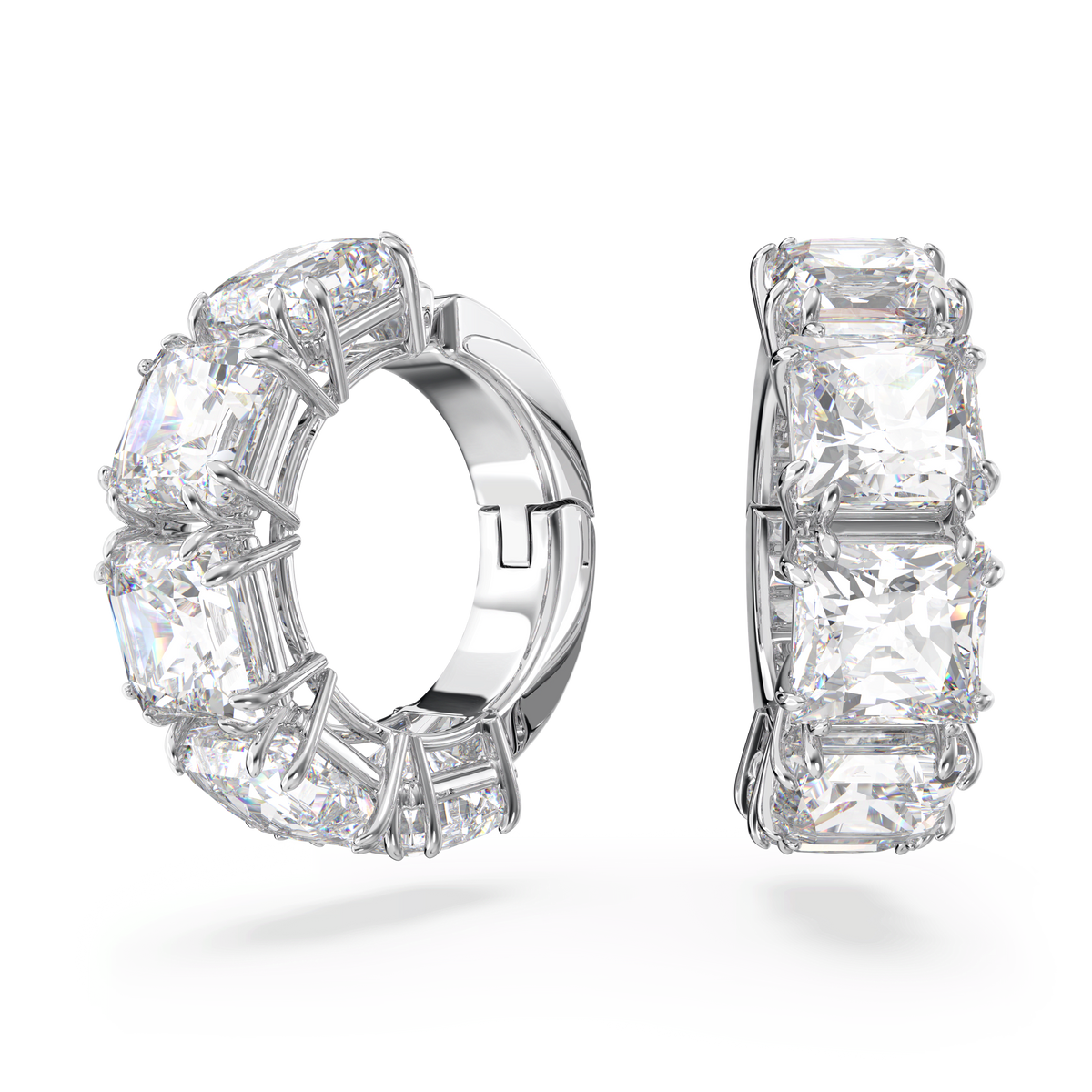 Two Swarovski Matrix clip earrings, each featuring large, square cut white gemstones set in a row and finished with rhodium plating, are beautifully displayed against a plain white background. These Swarovski earrings combine elegant sparkle with modern sophistication.