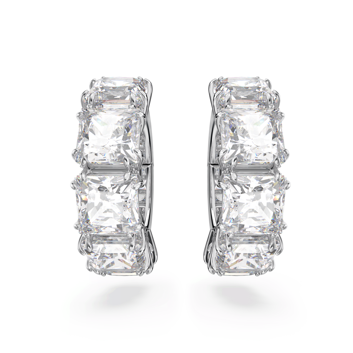 A pair of Swarovski Matrix clip earrings, featuring square-cut white stones and rhodium plating, are displayed upright on a plain white background.