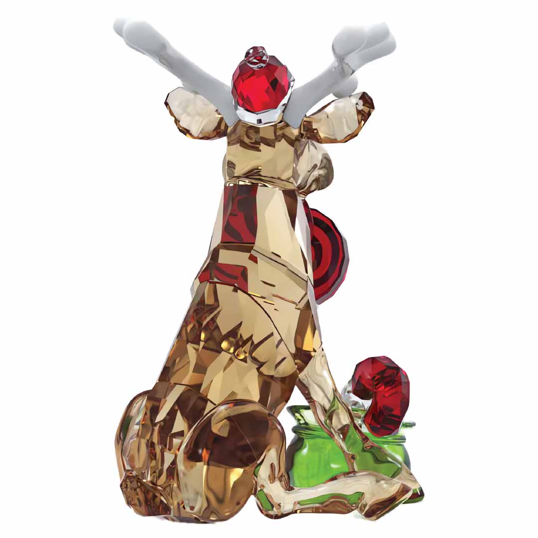 The Swarovski Holiday Cheers Dulcis Reindeer Home Décor is a festive collectible. This decorative glass sculpture features a reindeer figurine with white antlers, a shiny red nose, and a Santa hat, all perched on a green base. The seated reindeer boasts detailed facets that beautifully reflect the light.