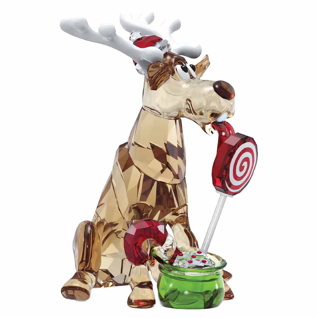 The Swarovski Holiday Cheers Dulcis Reindeer Home Décor by Swarovski is a charming crystal decoration featuring a whimsical glass reindeer with large antlers, festively licking a red and white swirled lollipop. One foot of this collectible piece touches a small green bowl brimming with colorful sweets, making it the perfect festive addition to any collection.