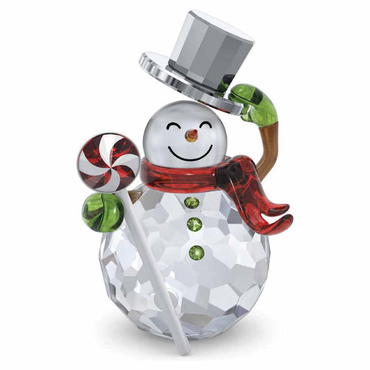 The Swarovski Holiday Cheers Dulcis Snowman Home Décor by Swarovski features a faceted crystal design, complete with a crystallized hat and a red scarf. The snowman holds a striped candy lollipop and is accented with a carrot nose and green button details, cheerfully smiling as its arm grasps the shiny top hat during the festive season.