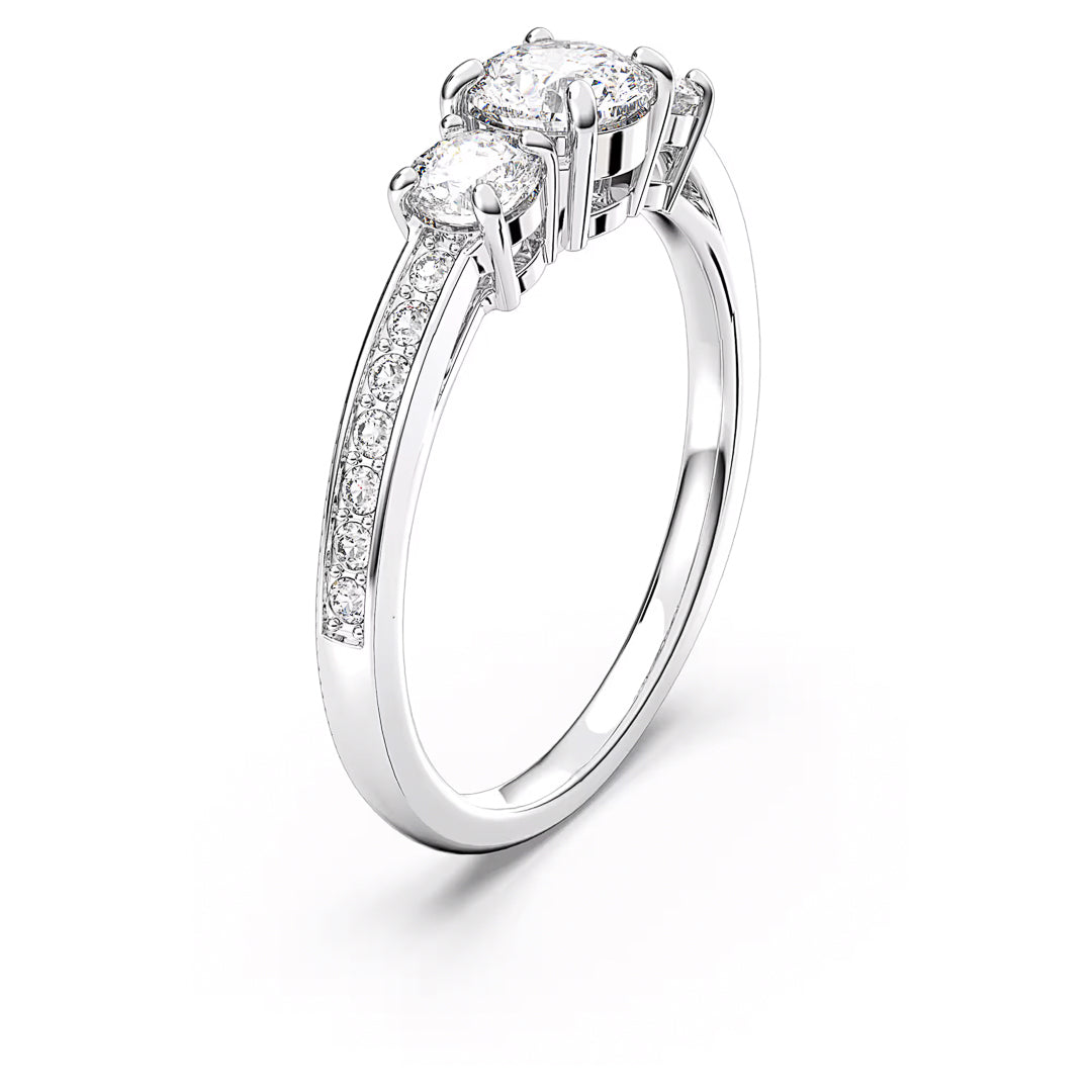 The Swarovski Attract Ring, crafted by Swarovski, showcases an elegant silver-tone finish with two main diamonds set side by side and additional smaller diamonds lining the band. Adorned with brilliant Swarovski Zirconia, it is positioned upright against a white background, highlighting its sparkling design.