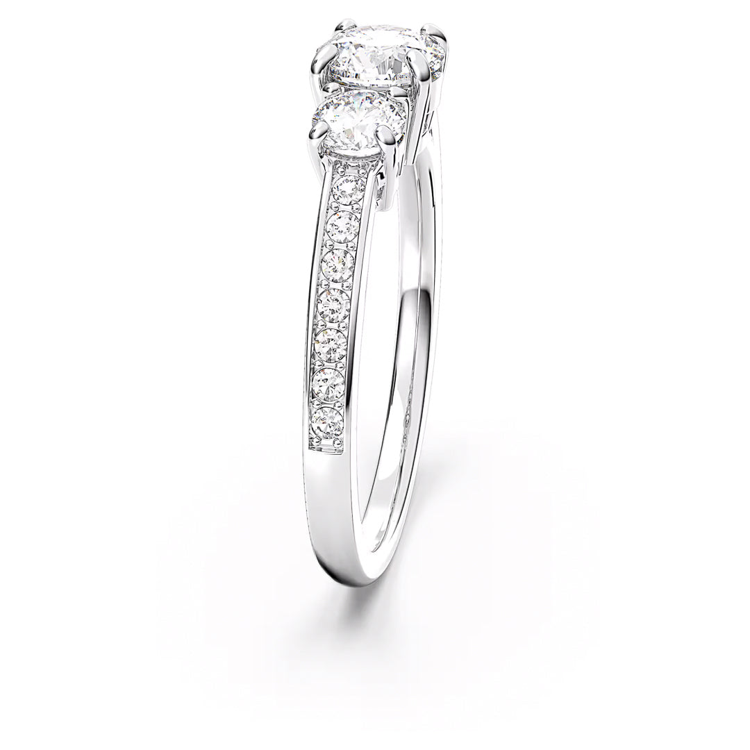 The Swarovski Attract Ring, skillfully designed with two main diamonds and a series of Swarovski Zirconia adorning the band, is elegantly displayed on a white background. This showcase highlights its intricate design and sparkling stones, all complemented by a stunning silver-tone finish.