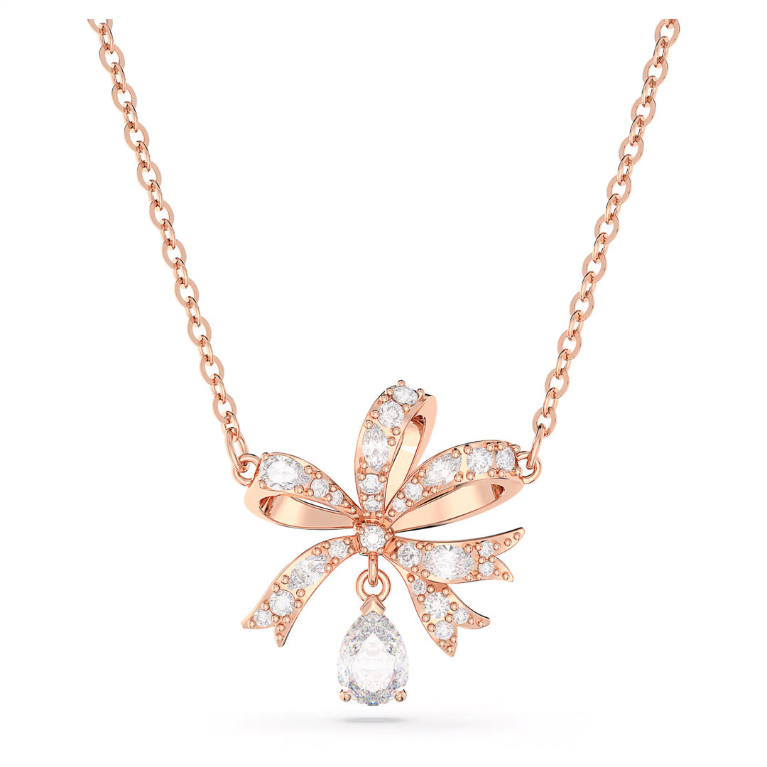 Introducing the Swarovski Hyperbola Necklace Pendant: a rose gold-tone plated piece from Swarovski, featuring a bow-shaped pendant adorned with small white crystals. A teardrop-shaped gemstone elegantly dangles from the center, perfectly complemented by the delicate chain's design.