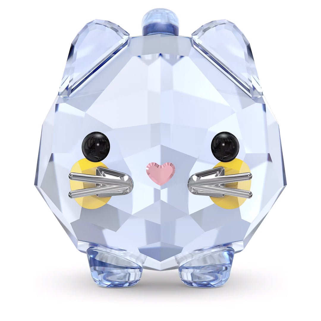 The Swarovski Chubby Blue Cat Home Décor piece beautifully captures a chubby cat with its crystal-clear, faceted surface. It features a light blue body, black eyes, a pink heart-shaped nose, silver whiskers, and yellow cheeks, standing upright like a dazzling gemstone.