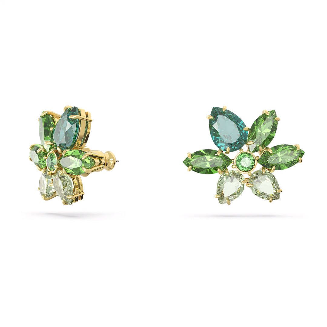 The Swarovski Gema Stud Earrings from Swarovski boast gold-tone plating, adorned with green and blue gemstones meticulously arranged in a floral pattern. This exquisite design features marquise, pear, and round cuts that harmonize light and dark green stones with a touch of blue, all enhanced by sparkling green crystals.