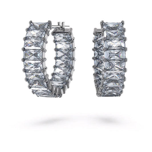 Close-up of Swarovski Matrix Hoop Earrings featuring elegant princess-cut clear gemstones set in shiny silver metal by Swarovski. The earrings are displayed against a plain white background, emphasizing their sparkling appearance.