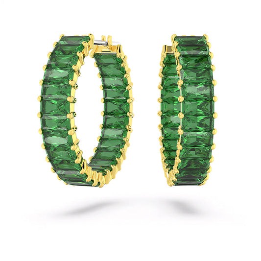 The Swarovski Matrix Hoop Earrings, by the renowned brand Swarovski, feature a gold-tone plating and stunning deep green stones arranged in rectangular shapes to create a perfect circle. Elegantly displayed side by side against a plain white background, they embody sophistication and style.
