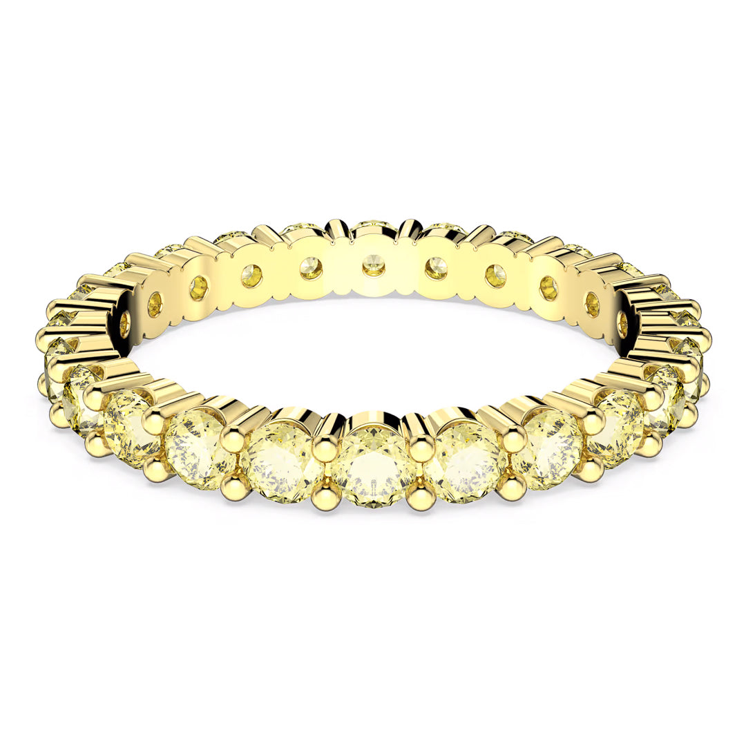 A close-up image of the Swarovski Matrix Ring, a luxurious piece by Swarovski, showcasing a luminescent design adorned with yellow stones. This elegant ring features a continuous row of sparkling oval-cut gems in an exquisite prong setting, beautifully enhanced by gold-tone plating for a radiant appearance.