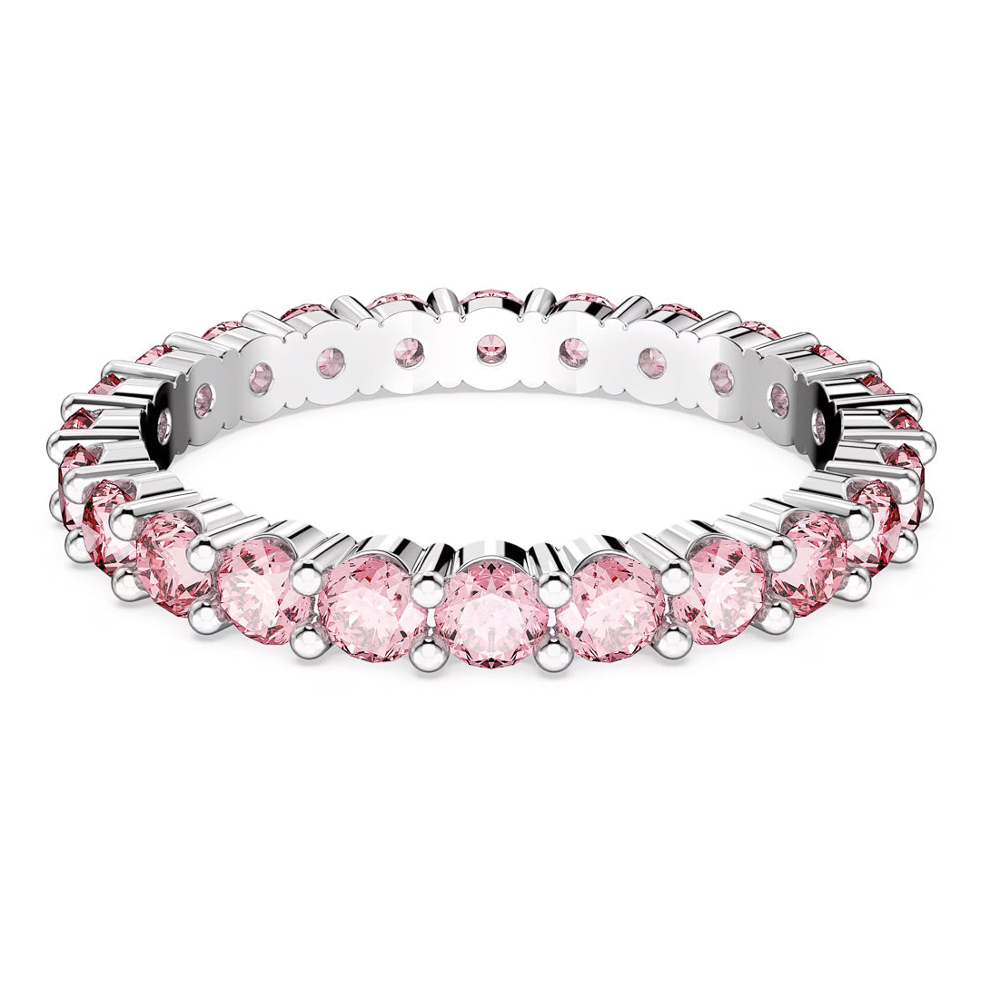The Swarovski Matrix Ring by Swarovski is a silver eternity ring that showcases a continuous line of round pink zirconia gemstones set in a minimalist prong setting and plated with rhodium, offering a shimmering sparkle that enhances its elegant design.