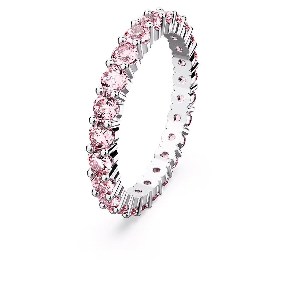 The Swarovski Matrix Ring, a rhodium-plated silver eternity band featuring round pink zirconia gemstones perfectly spaced around the entire ring, is elegantly presented against a white background.