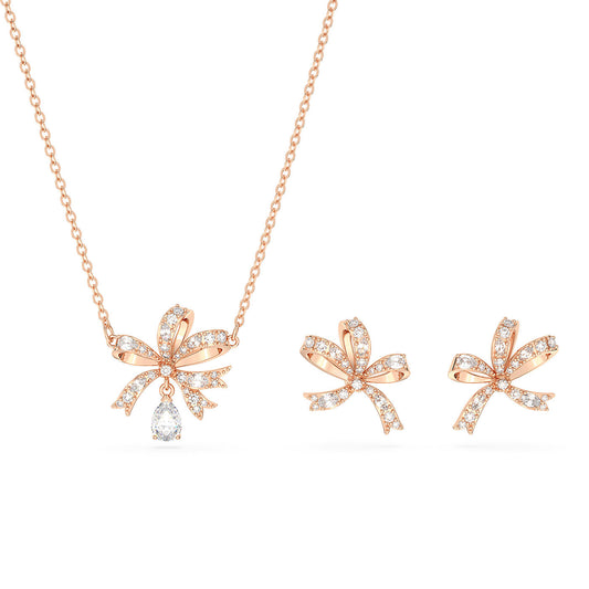 The Swarovski Volta Bow Necklace and Earrings Set by Swarovski features rose gold-tone jewelry adorned with bow designs. The necklace is highlighted by a drop-shaped pendant at the center of the bow, both embellished with sparkling clear crystals.