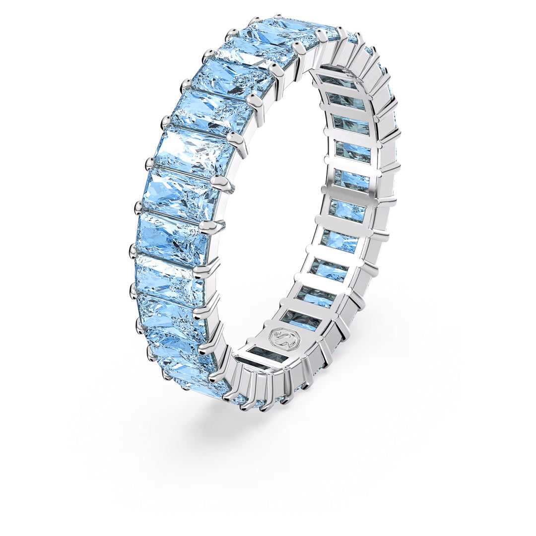 The Swarovski Matrix Ring features a series of rectangular, light blue aquamarine gemstones in a continuous band design. These princess baguette-cut stones are secured by a series of clasps, showcasing their clarity and enhancing their reflective qualities.