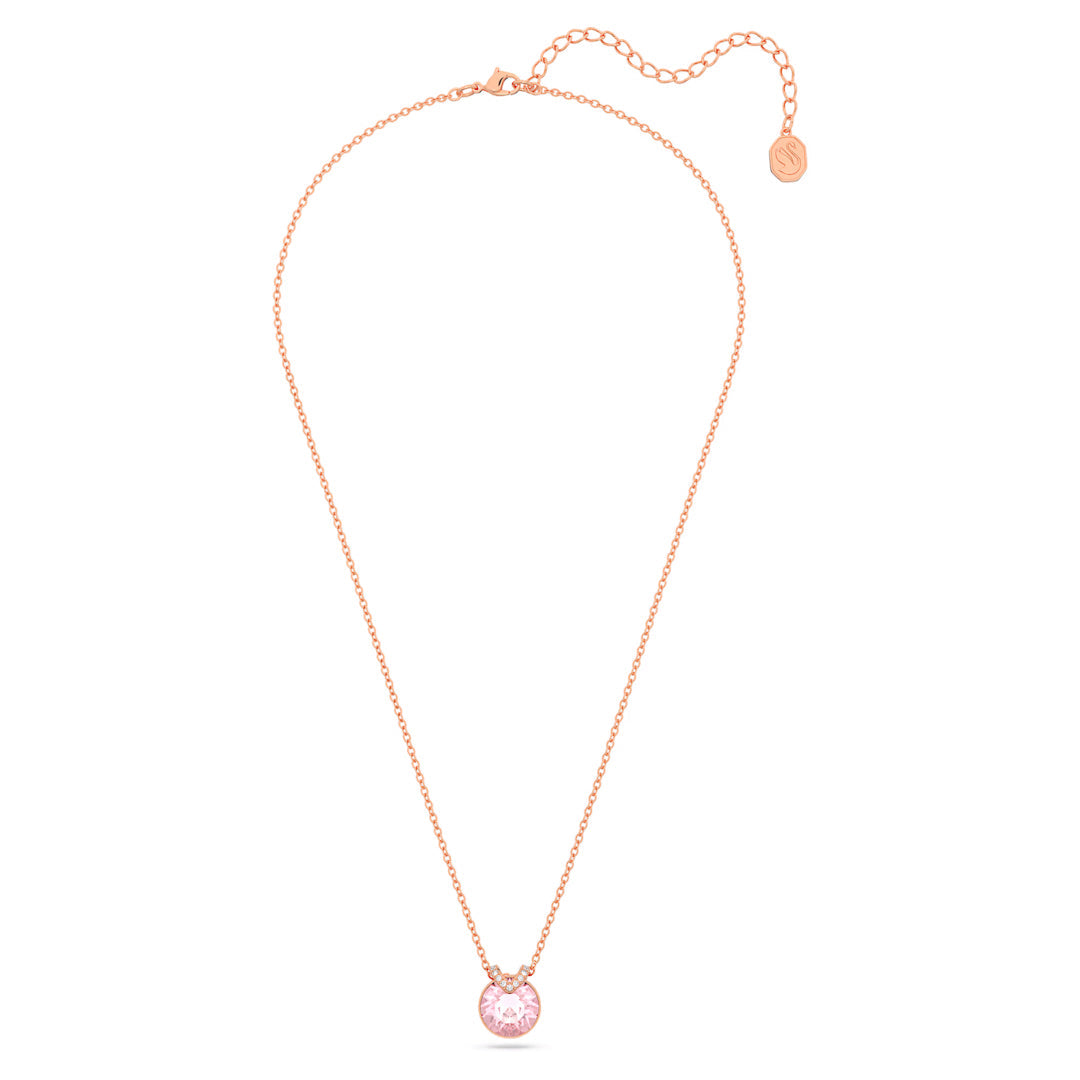 The Swarovski Bella V Necklace Pendant, by Swarovski, is a romantic piece featuring a delicate rose gold-tone plating. It has a thin chain that elegantly highlights its pink center stone pendant and concludes with an adjustable clasp accompanied by a small, round gold tag.