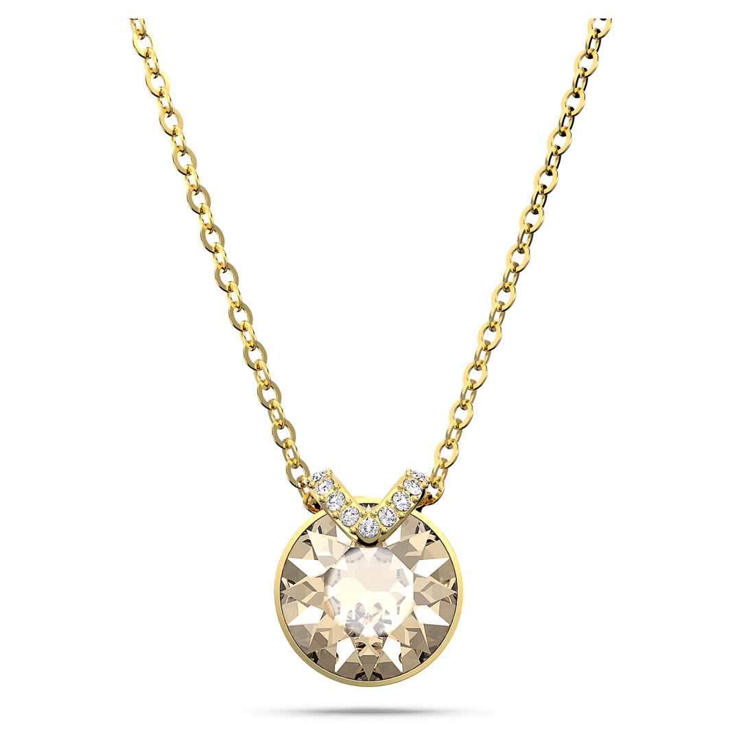 The Swarovski Bella V Necklace Pendant by Swarovski features a gold-tone design with a mesmerizing center stone set in a round pendant, accented by delicate pavé gemstones arranged in a "V" above the crystal. The chain is crafted from fine gold links.