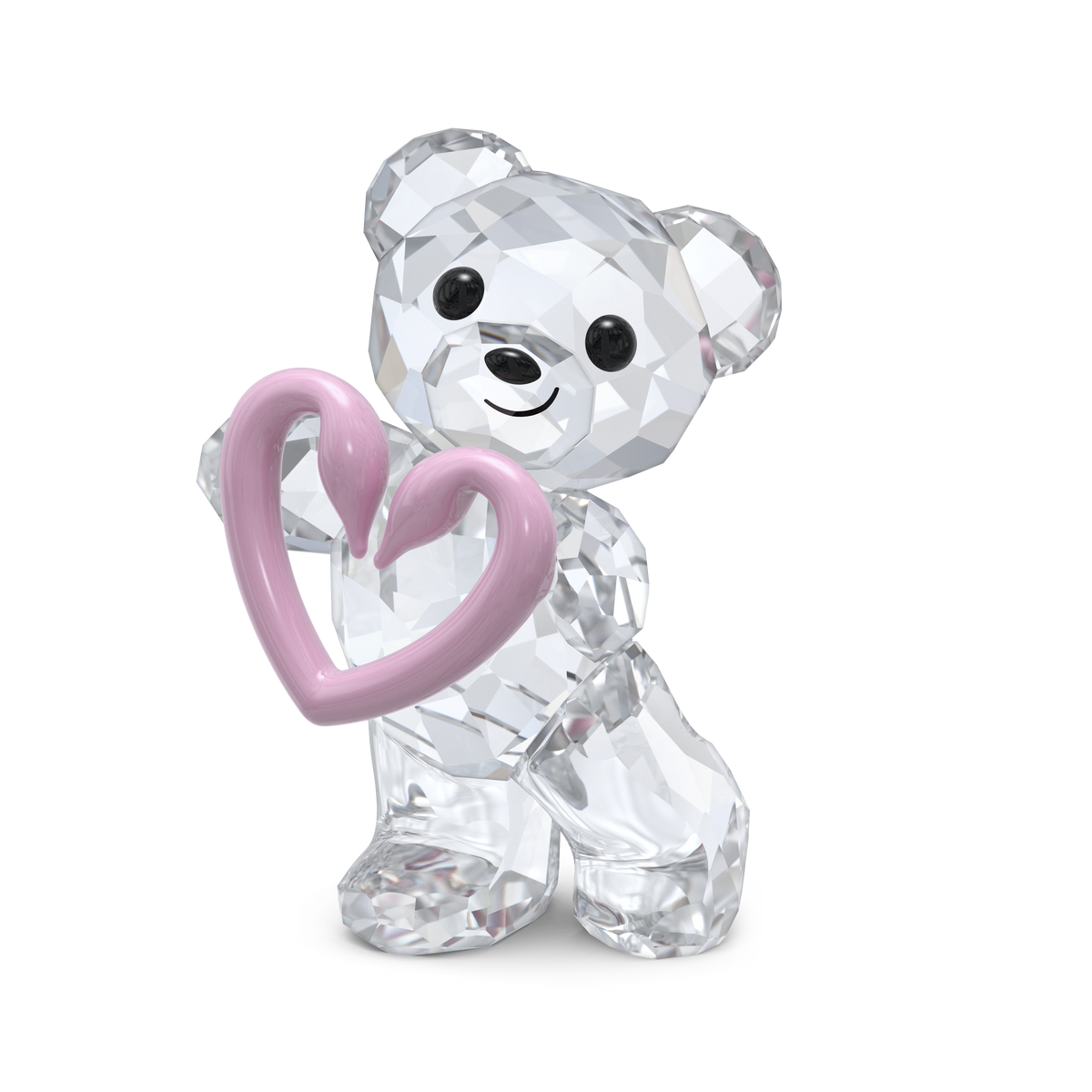 The Swarovski Kris Bear Una Bear figurine, from the Authentic Swarovski collection, features clear crystal with black eyes and nose and holds a pink heart. The smiling bear stands on one foot against a plain white background.