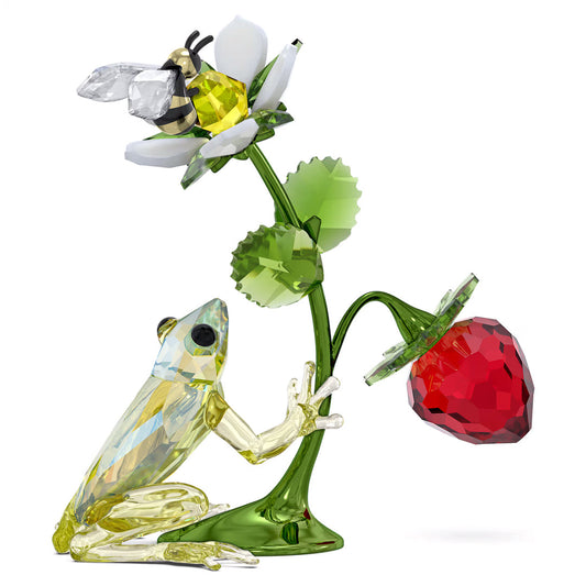 The Swarovski Idyllia Frog Bee and Strawberry Home Décor piece by Swarovski features a colorful frog reaching for a flower, with a bee perched gracefully atop it. Below, there's a vibrant red crystal strawberry hanging delicately from the green stem. These intricately designed elements boast a sparkling finish that captivates any observer.