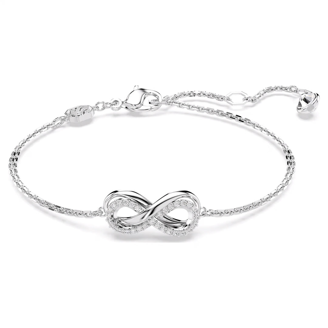 The Swarovski Hyperbola Bracelet by Swarovski is a delicate silver piece featuring an elegant infinity motif at its center. Adorned with sparkling Swarovski Zirconia, it comes with a fine chain and an adjustable clasp for secure wear.