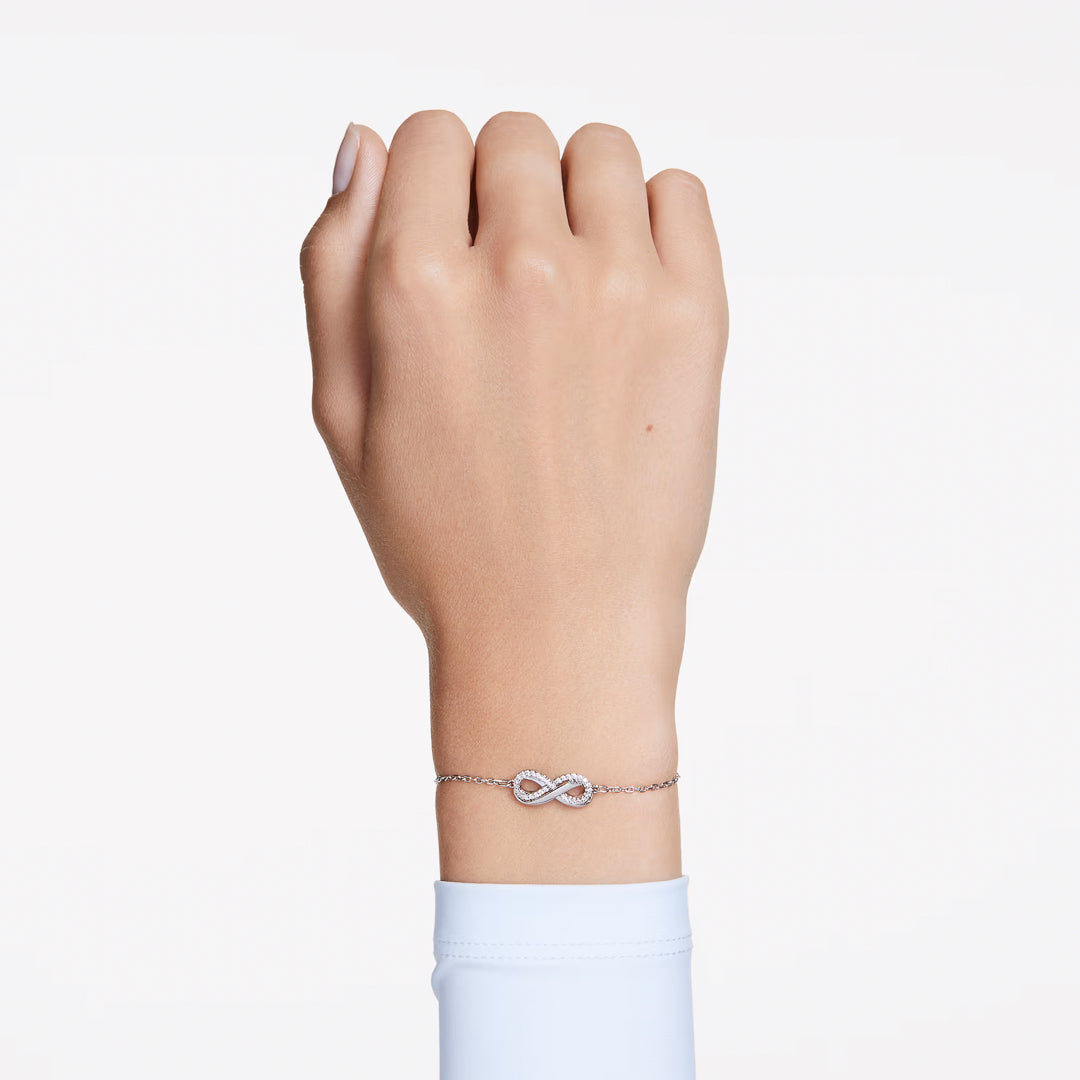 The Swarovski Hyperbola Bracelet graces the wrist with its elegant infinity motif, beautifully embedded with Swarovski Zirconia. Set against a plain white background, the bracelet's stunning design takes center stage.