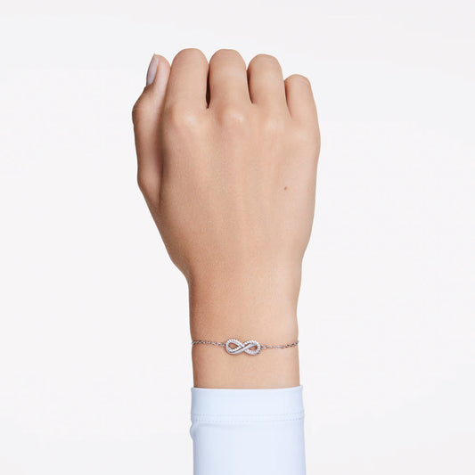 The Swarovski Hyperbola Bracelet graces the wrist with its elegant infinity motif, beautifully embedded with Swarovski Zirconia. Set against a plain white background, the bracelet's stunning design takes center stage.